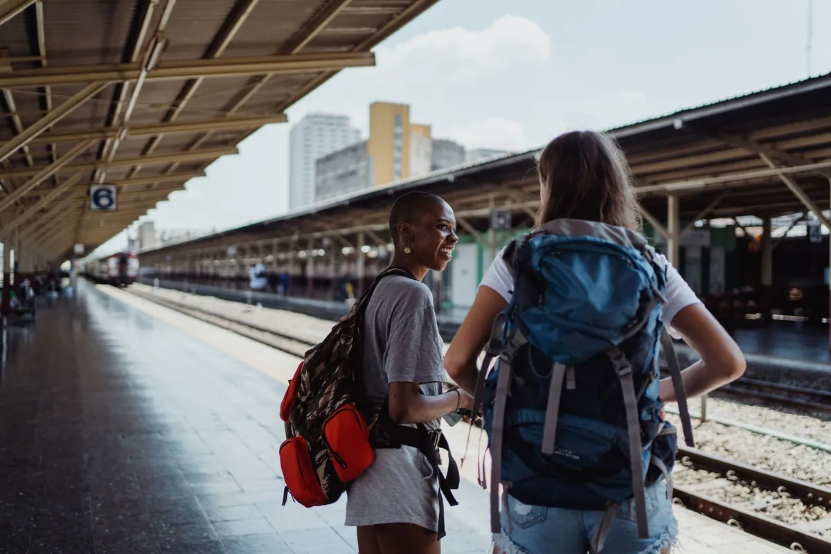 Deux voyageuses sac au dos sur un quai de gare