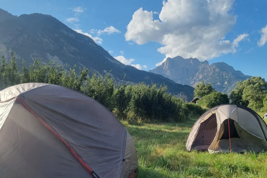 Tentes dans un pré face aux montagnes