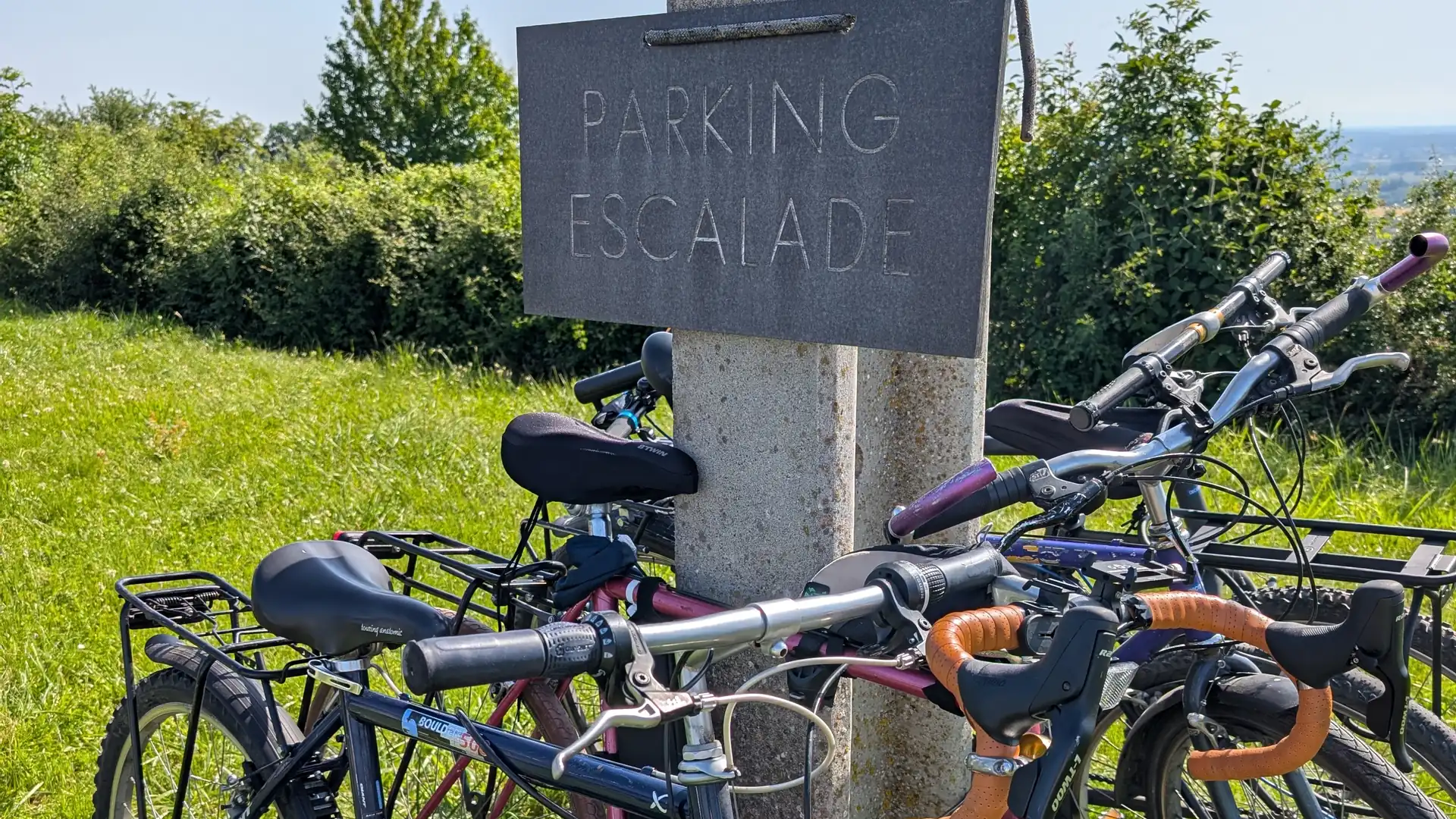 Vélos attachés au panneau « Parking escalade » au pied des falaises